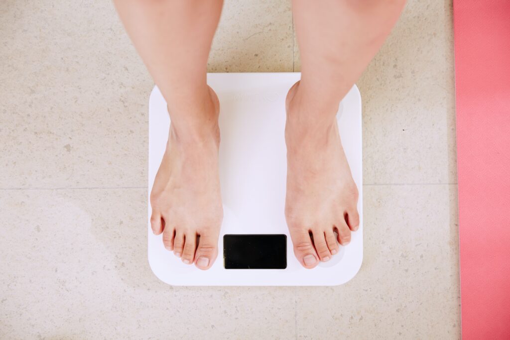 a person standing on weight measuring scale.